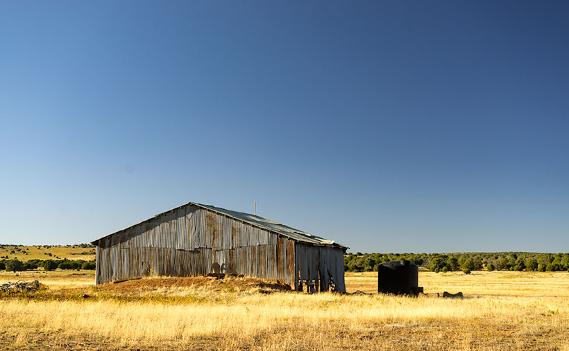 Corrugated metal shed on a ranch outside Bagdad, AZ, a testament to the practicality of rural farm storage in the desert.