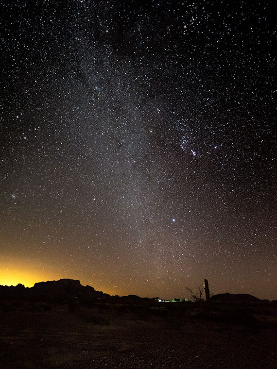 Silhouette of KofA Mountains against Phoenix lights, with the Milky Way and Orion constellation rising in the night sky.