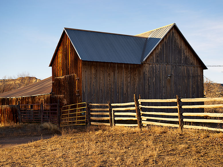 Photo of historic Escalante Barn with a split rail fence corral.