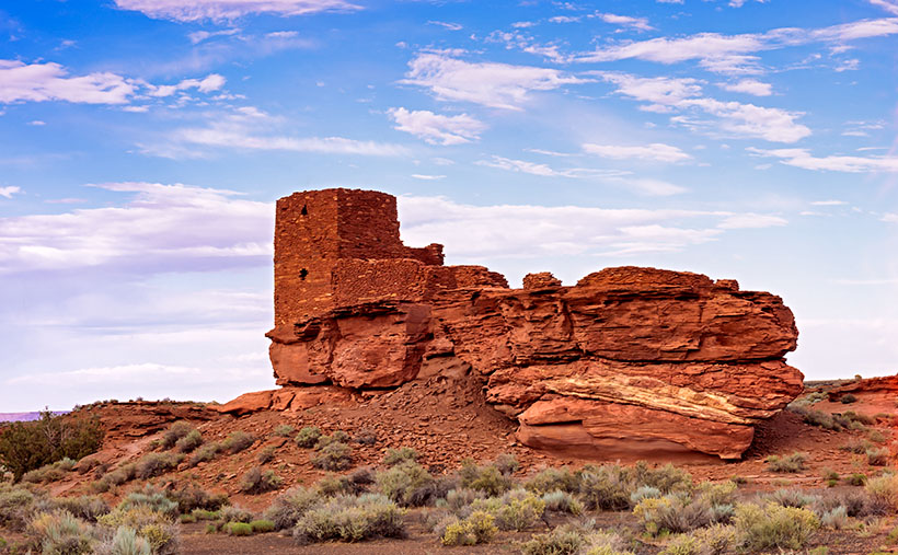 The Wukoki pueblo ruins rising starkly from the arid landscape at Wupatki National Monument under a painted sky.