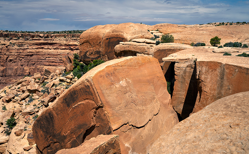 Large fractured sandstone block perched on the edge of Cedar Mesa, shaped by natural erosion processes