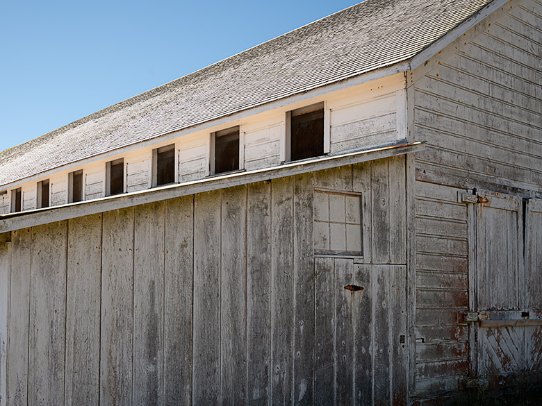 Close-up of weathered upper windows on a rustic building at Pierce Point Ranch, Point Reyes, California