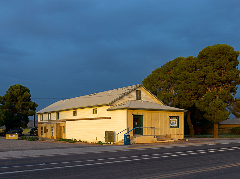 The Palo Verde Post Office glows in the predawn light under dark storm clouds. Photo by Jim Witkowski.