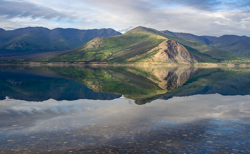The Ruby Range is reflected in the calm waters of Kluane Lake.