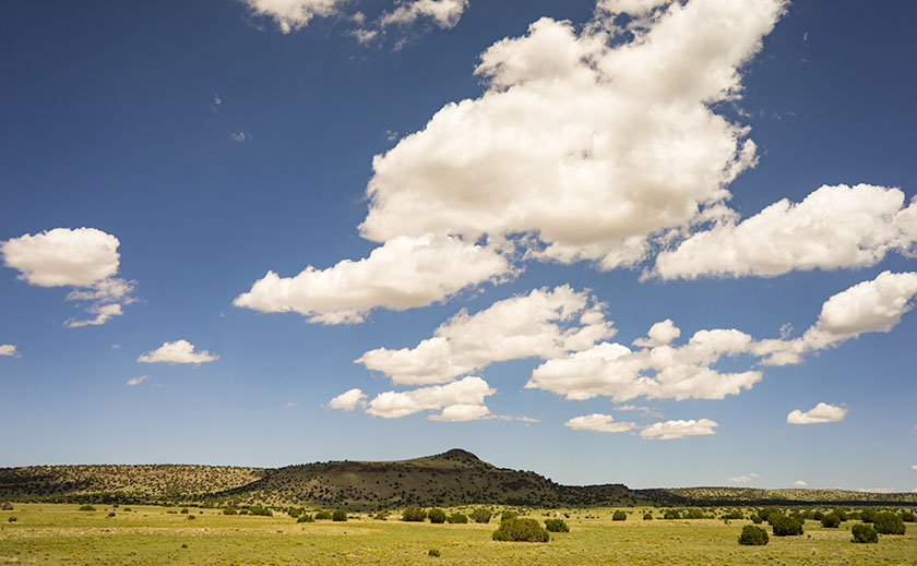 Puffy clouds hang over cinder hills west of Quemado, New Mexico