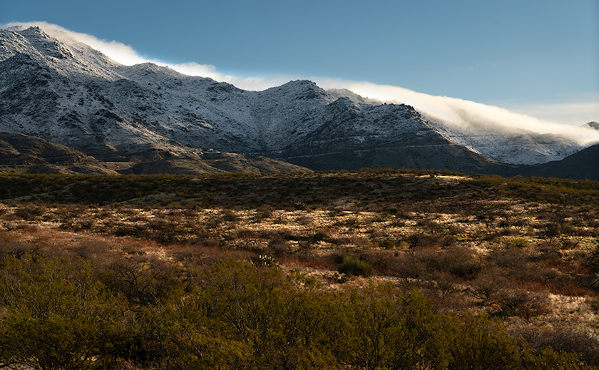 Snow-covered Weaver Mountains with clouds caressing the peaks, viewed from Congress, Arizona