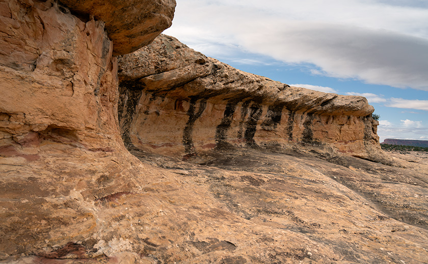 Eroded rock overhang with dark varnish stains in Natural Bridges National Monument