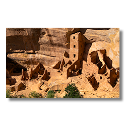 The intricate Tower House ruins nestled within the cliff face of Mesa Verde National Park, as seen from an overhead vantage point.