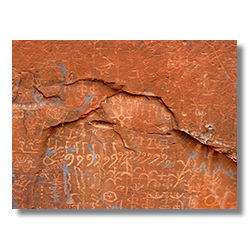 Confront the harsh reality of 'vandalizedGraffiti', where the sacred petroglyphs on Navajo land near Tuba City bear the marks of modern disregard on ancient canvases.