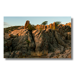 A subtle sunrise over the Granite Dells in Prescott, Arizona, highlighting lichen-covered rocks resembling toes and victory signs.