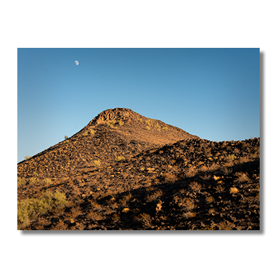 Basalt-covered mountain peak in Agua Caliente, likely formed by volcanic fissure eruptions, with the moon rising above.