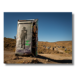 Sheriff graffiti on a car at Goldfield’s International Car Forest, surrounded by unique planted vehicles in the Nevada desert.