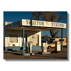 Vintage gas station with faded signage and classic Route 66 fuel pumps in Truxton, Arizona, bathed in morning sunlight.